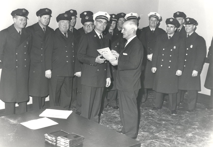 Director of Public Safety Edward Garrity presents Chief Edward MacDowell with a municipal proclamation