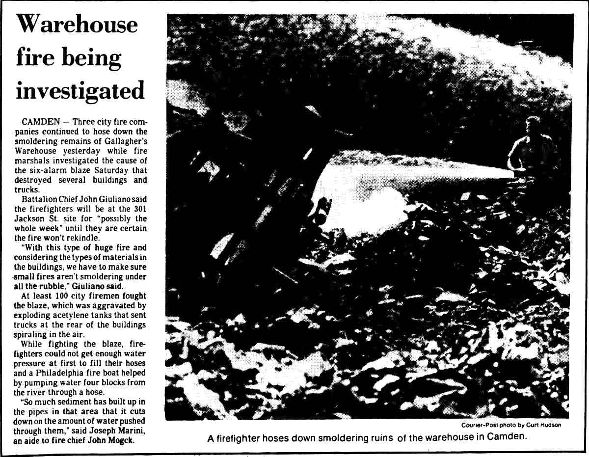 A firefighter hoses down smoldering ruins of the Eavenson & Levering warehouse in Camden, August 1982