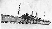 USS DeKalb in port with a small tug alongside, 1919