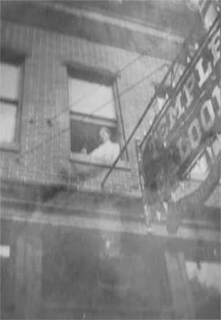 Jennie Gondolf at a second floor window of the Temple Saloon