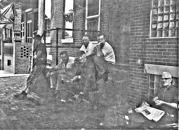 1960s Tiedeken employees taking a break out front, George Birch seated wearing cap