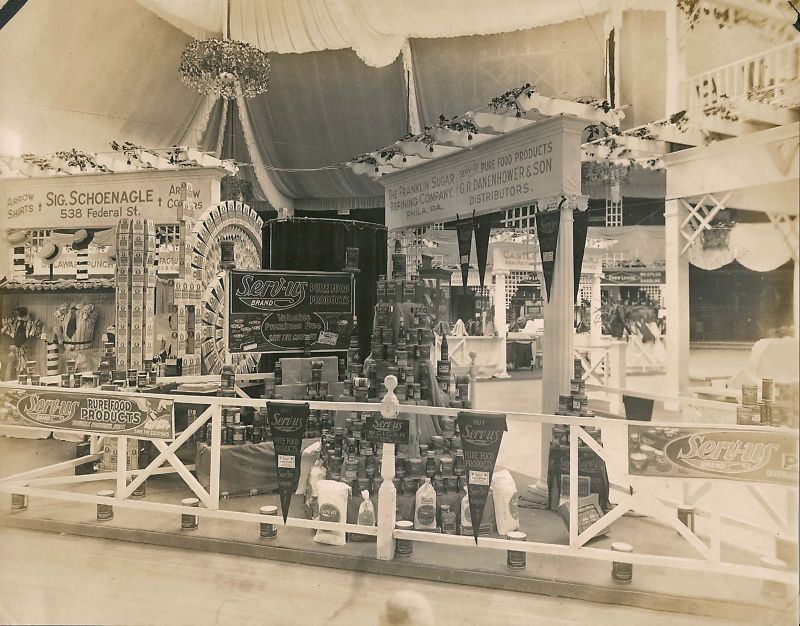 Camden Trade Expo 1918 — G.R. Danenhower & Son booth displaying Serv-us Brand Pure Food Products, with adjacent Sig. Schoenagle booth