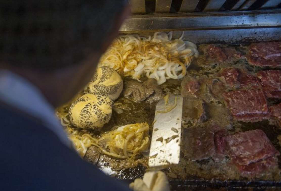 Thin rib-eye steak, onions, and cheese on the grill at Donkey's Place