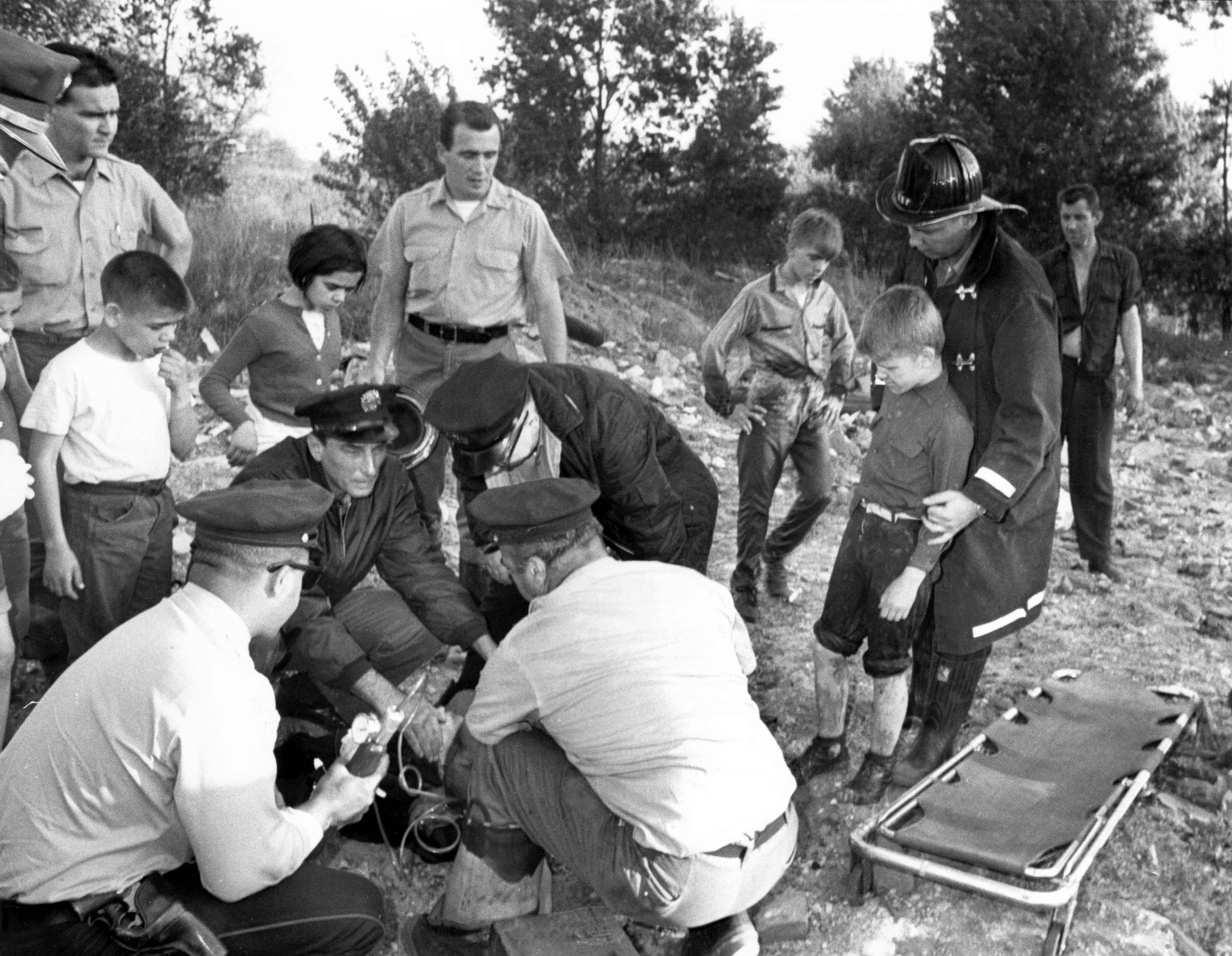 Members of Rescue Company 1 administering oxygen and first aid following rescue of juveniles trapped on Cooper River mudflats, North 10th Street and State Street, 1965