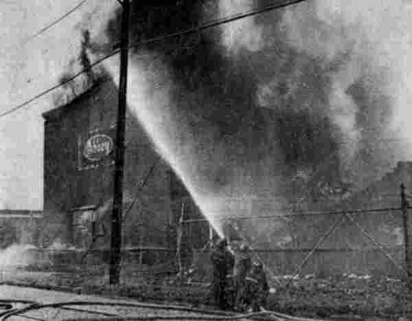 Firemen directing a hose on the burning paper warehouse, May 8, 1972