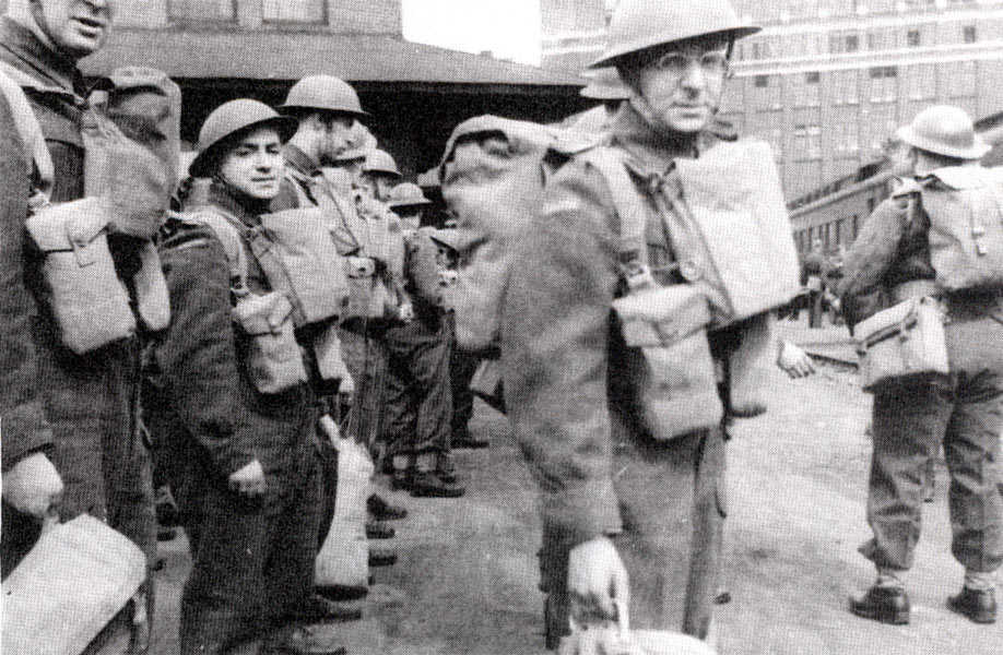 Circa 1942: Private Herman (in foreground, wearing glasses) and comrades preparing to board troop train at Toronto for Halifax