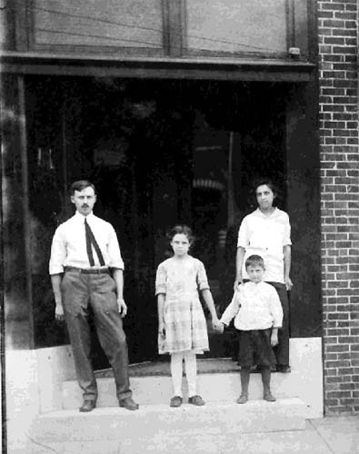 Francis X. Braun & children outside his tailor shop, 1910