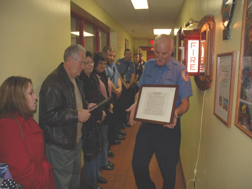 Engine Co. 8 Captain J. J. Johnston presenting family members with a plaque, December 9, 2007