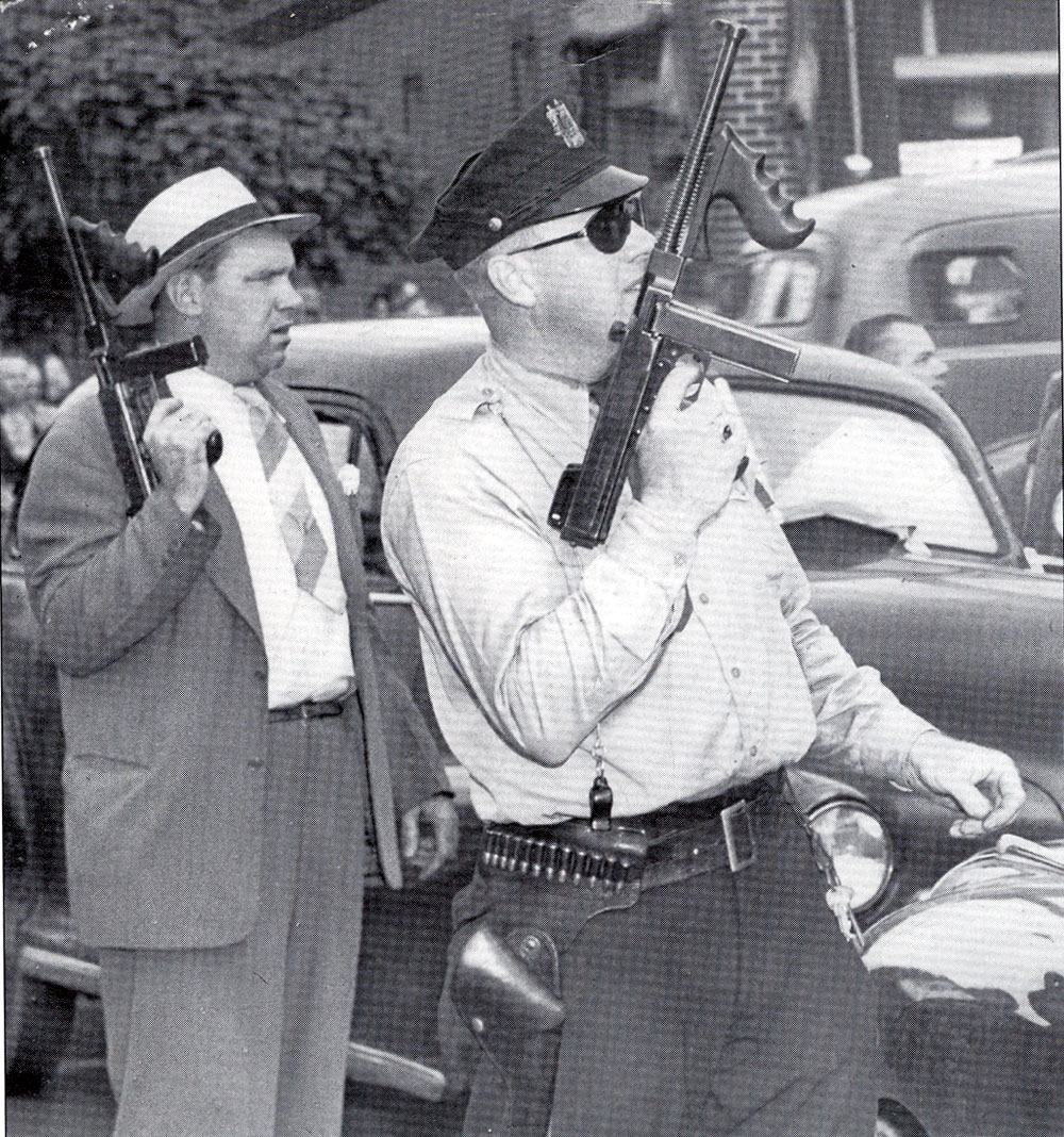 Two of the more than 50 Camden police officers who helped capture Howard Unruh, Detective William Kelley (left) and Officer Charles Hance hold their guns during the exchange of fire between officers and Unruh, who barricated himself in his River Avenue apartment after the mass killing. Photo taken September 5, 1949. Courier-Post photo.